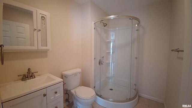 bathroom featuring tile patterned flooring, toilet, vanity, and walk in shower