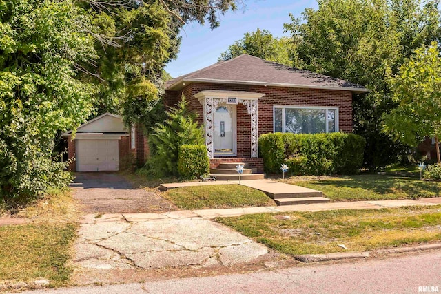 view of front facade featuring a garage, an outdoor structure, and a front lawn