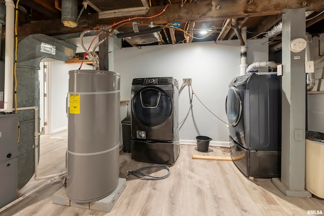 laundry room featuring light wood-type flooring and water heater