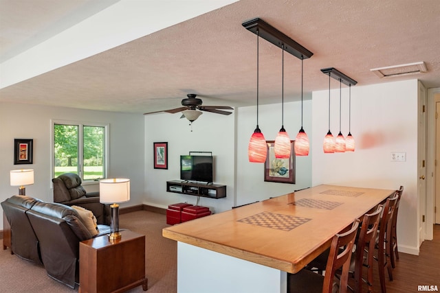 kitchen with pendant lighting, ceiling fan, kitchen peninsula, and a textured ceiling