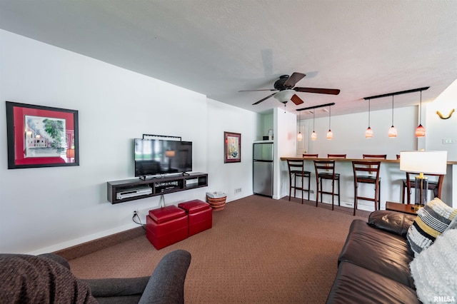 carpeted living room featuring ceiling fan and a textured ceiling