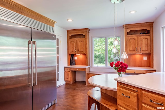 kitchen featuring hanging light fixtures, built in desk, dark wood-type flooring, and stainless steel built in fridge