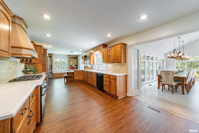 kitchen featuring premium range hood, pendant lighting, dishwasher, gas stove, and dark wood-type flooring