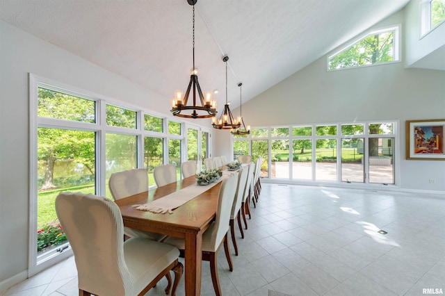 dining space featuring light tile patterned floors, a wealth of natural light, high vaulted ceiling, and a chandelier