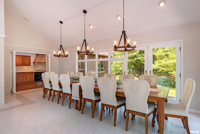 dining area featuring high vaulted ceiling, light tile patterned floors, and an inviting chandelier