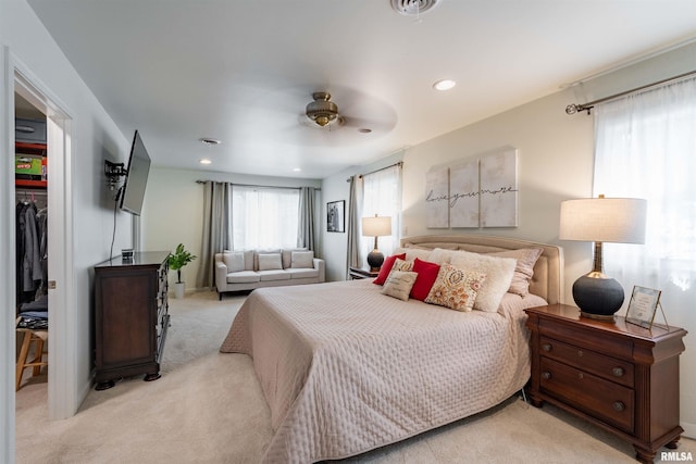 carpeted bedroom with a walk in closet and a closet