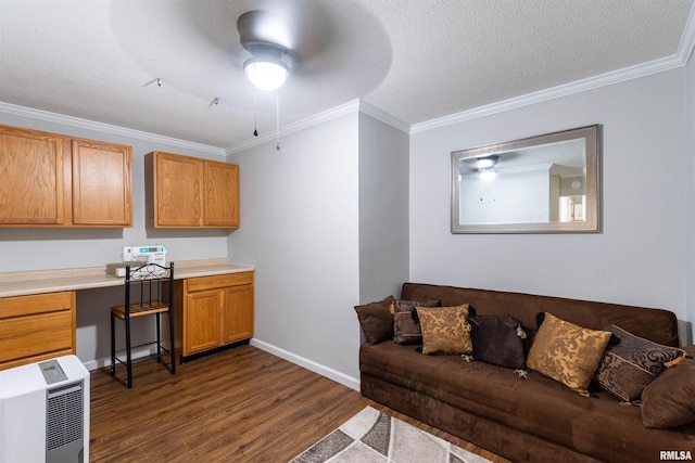 kitchen featuring ceiling fan, heating unit, built in desk, ornamental molding, and dark hardwood / wood-style flooring