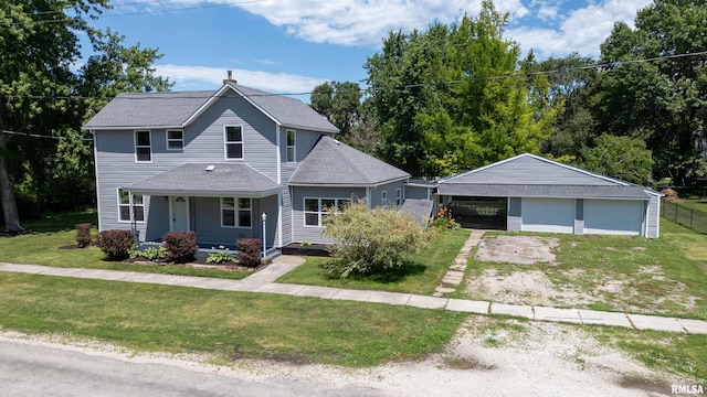 view of front facade featuring a porch, a garage, a front lawn, and an outdoor structure