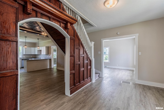 foyer entrance featuring wood-type flooring and a textured ceiling