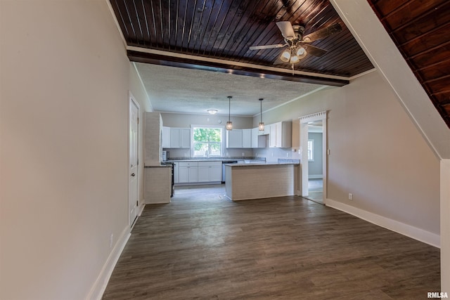 kitchen featuring ceiling fan, a center island, dark wood-type flooring, pendant lighting, and white cabinets