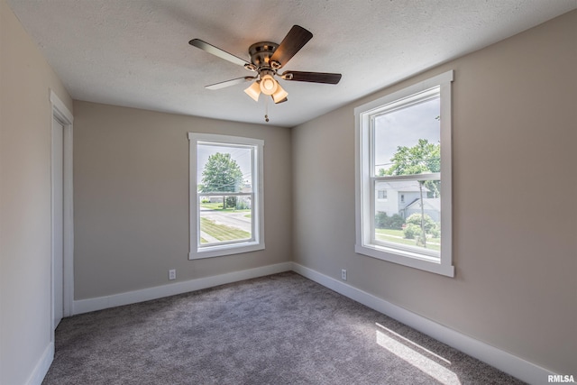 empty room with ceiling fan, carpet, and a textured ceiling