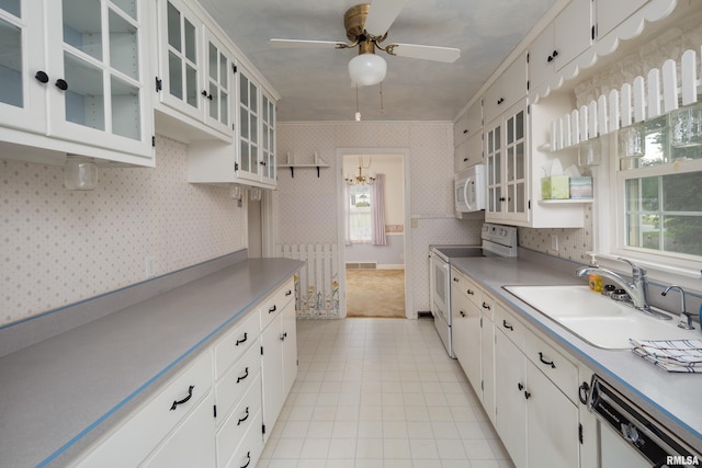 kitchen with white appliances, white cabinets, ceiling fan with notable chandelier, crown molding, and sink