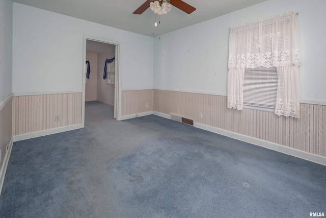 unfurnished room featuring dark colored carpet and ceiling fan