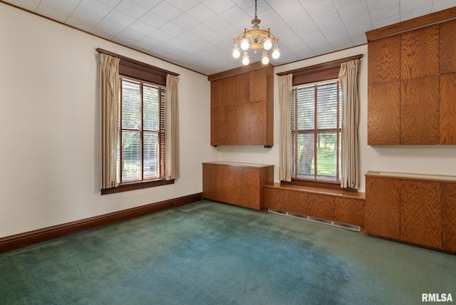 carpeted empty room featuring a healthy amount of sunlight and a notable chandelier