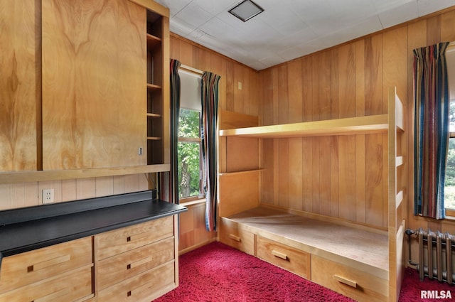 unfurnished bedroom featuring wood walls and radiator