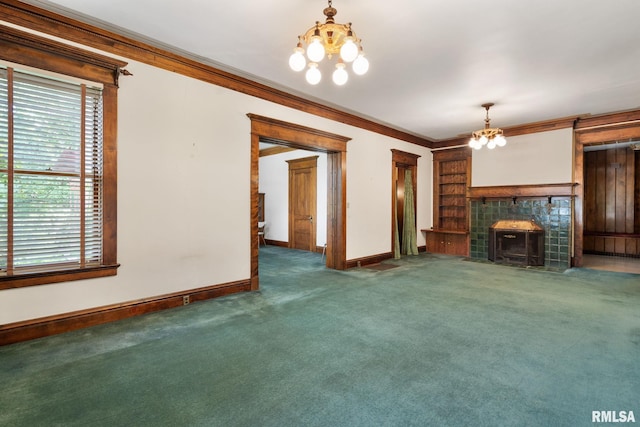 unfurnished living room featuring crown molding, a tile fireplace, a notable chandelier, and dark carpet