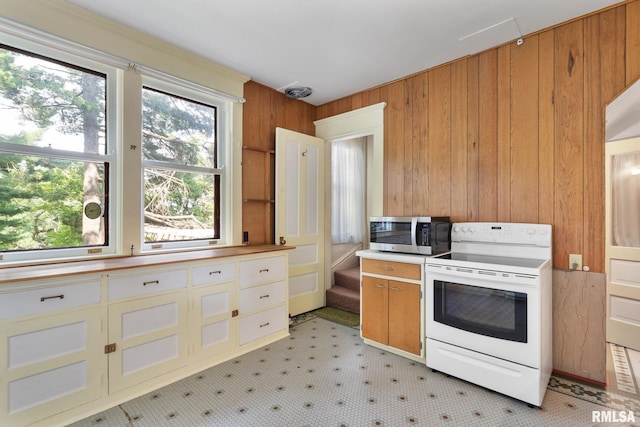 kitchen with white range with electric cooktop and wooden walls