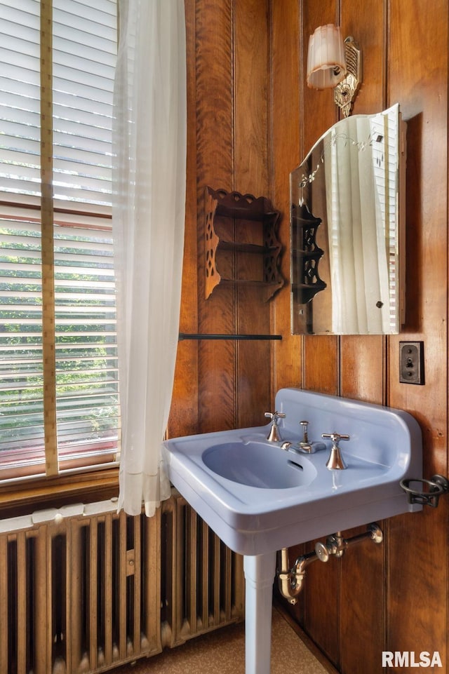 bathroom featuring wood walls and radiator heating unit