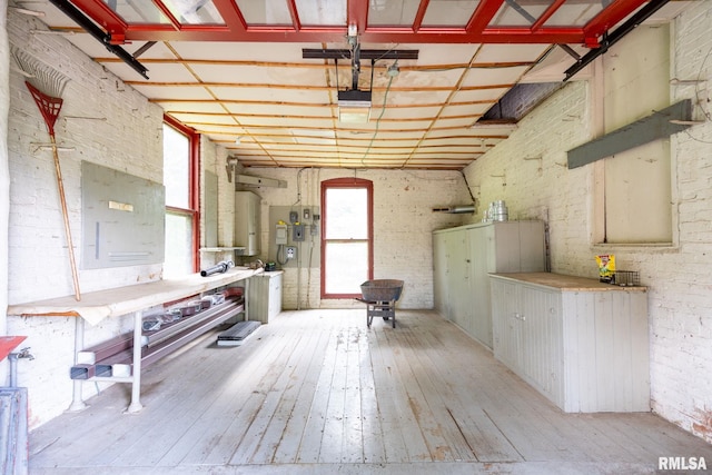 interior space with hardwood / wood-style flooring, water heater, and electric panel