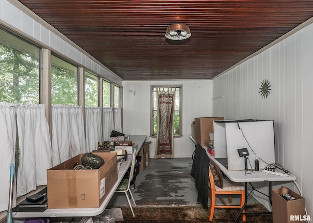 interior space featuring wood ceiling, wood walls, and concrete floors