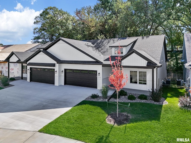 view of front of house with a front yard, a garage, and central air condition unit