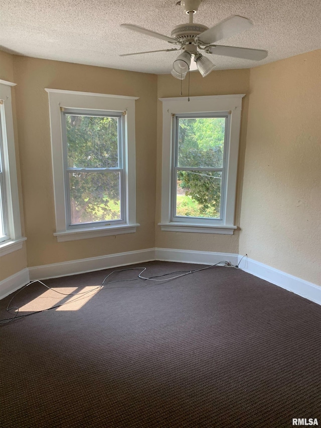 unfurnished room featuring baseboards, a textured ceiling, and a healthy amount of sunlight