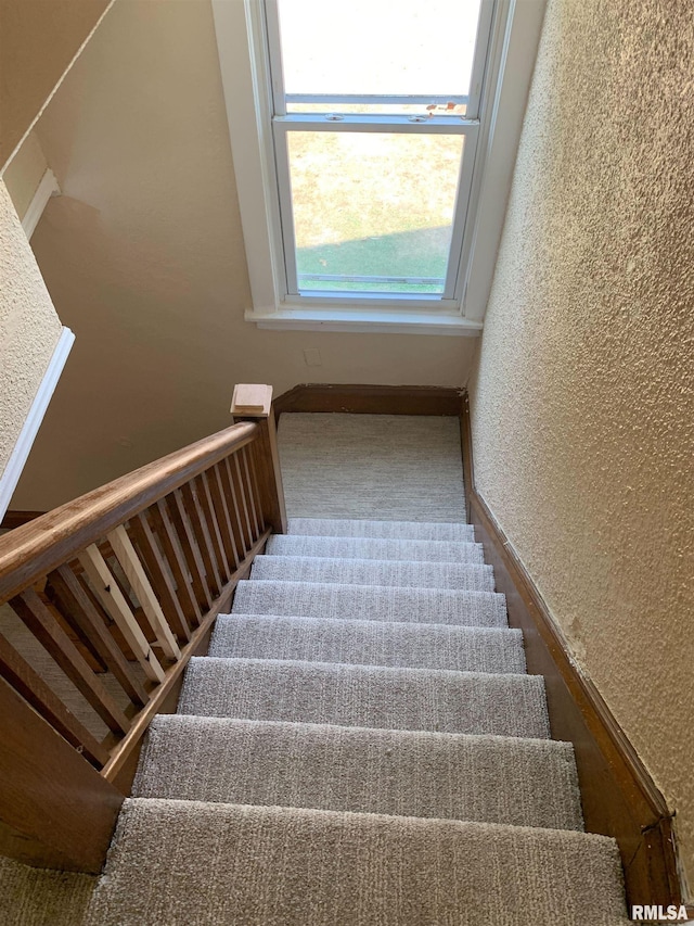 stairs featuring a textured wall