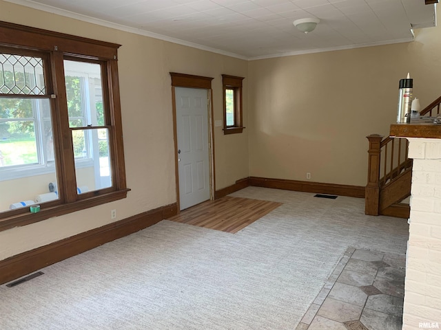 carpeted foyer entrance featuring baseboards, stairway, visible vents, and crown molding