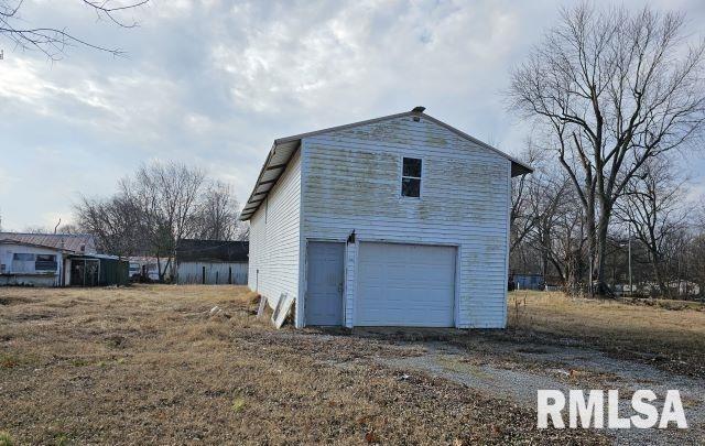 view of property exterior with a garage and an outdoor structure