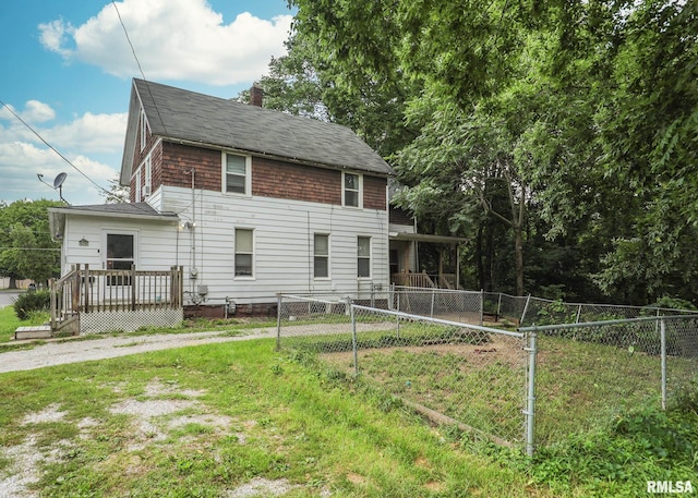 view of front facade featuring a wooden deck and a front yard