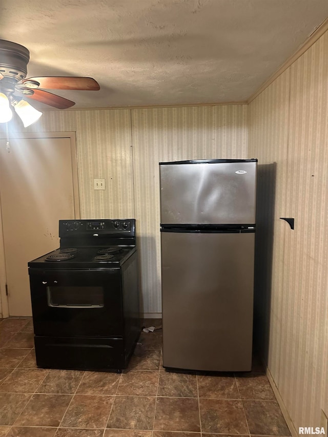 kitchen with black electric range, ceiling fan, dark tile patterned floors, and stainless steel fridge