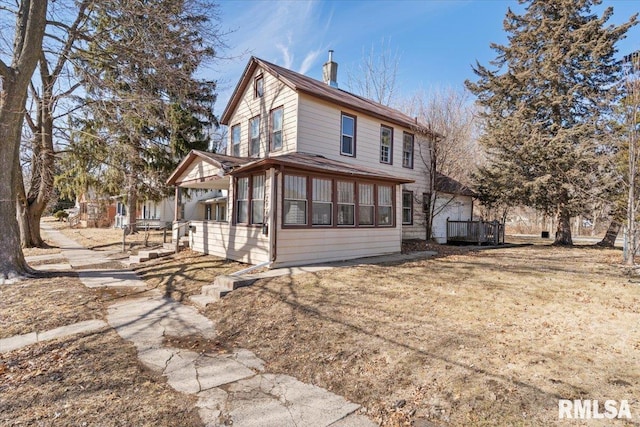 exterior space with a sunroom and a chimney