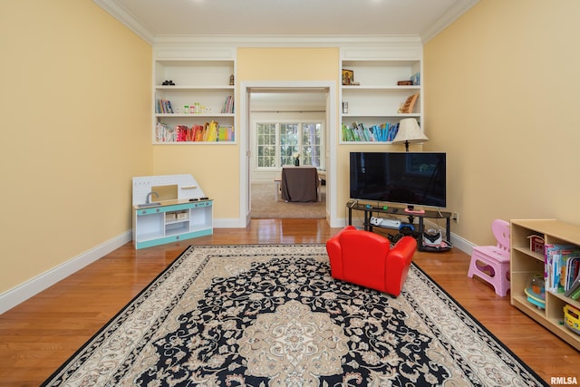 interior space with built in shelves, wood-type flooring, and ornamental molding