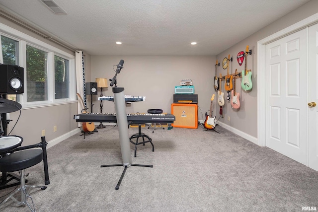 exercise room featuring a textured ceiling and carpet floors