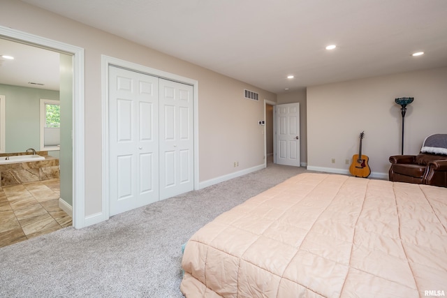 bedroom with a closet, connected bathroom, and carpet floors