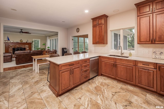 kitchen featuring a fireplace, kitchen peninsula, ceiling fan, tasteful backsplash, and stainless steel dishwasher