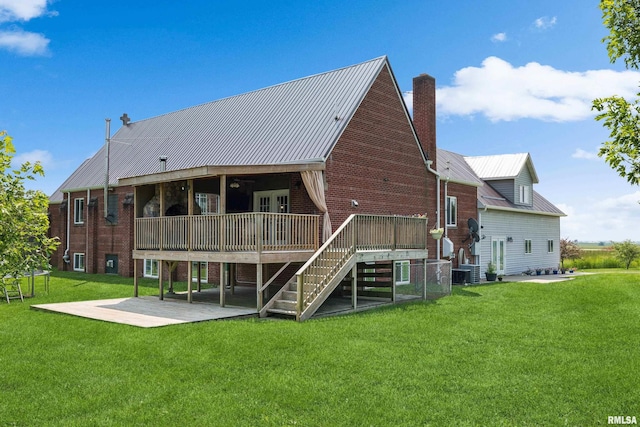 back of property with a wooden deck, a yard, central AC, and a patio area