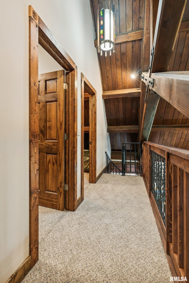 hall with lofted ceiling, carpet flooring, and wooden ceiling