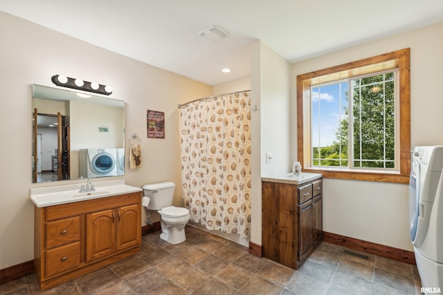 bathroom featuring toilet, vanity, and washer / clothes dryer