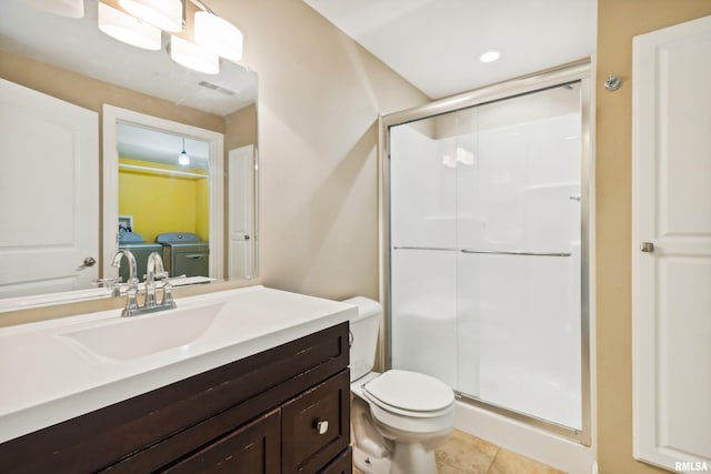 bathroom featuring tile patterned flooring, vanity, washer and clothes dryer, and walk in shower