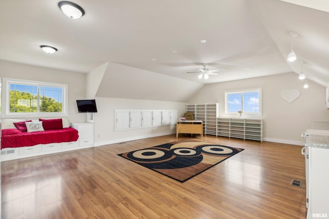 bedroom featuring multiple windows, lofted ceiling, light wood-type flooring, and ceiling fan