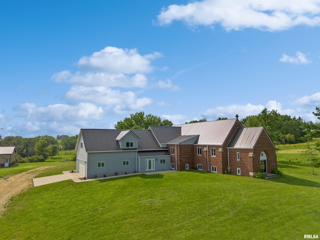 back of house with a garage and a lawn