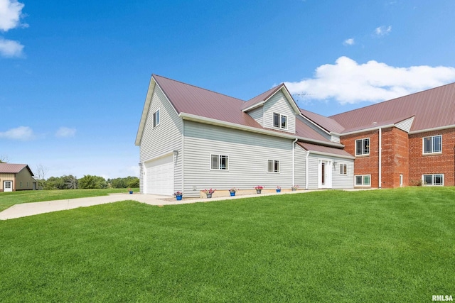 back of house featuring a yard and a garage