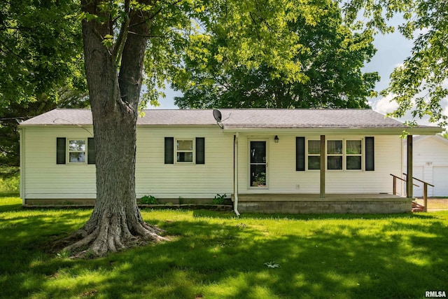 rear view of property featuring a yard and a garage