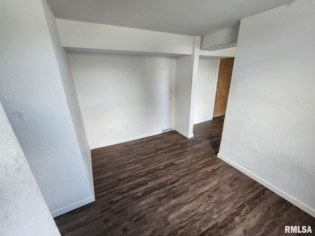 spare room featuring dark wood-type flooring