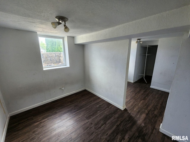 unfurnished room with dark hardwood / wood-style flooring and a textured ceiling