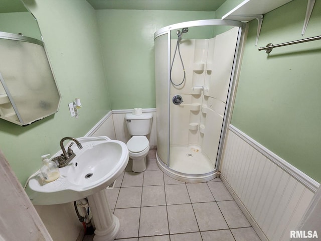 bathroom with tile patterned floors, toilet, and an enclosed shower