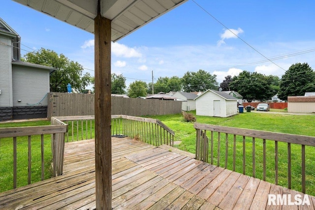 wooden terrace featuring a storage shed and a lawn