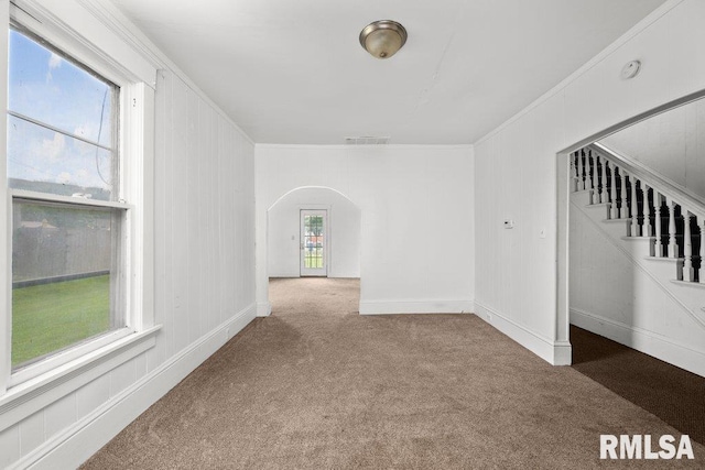 spare room with ornamental molding and light carpet