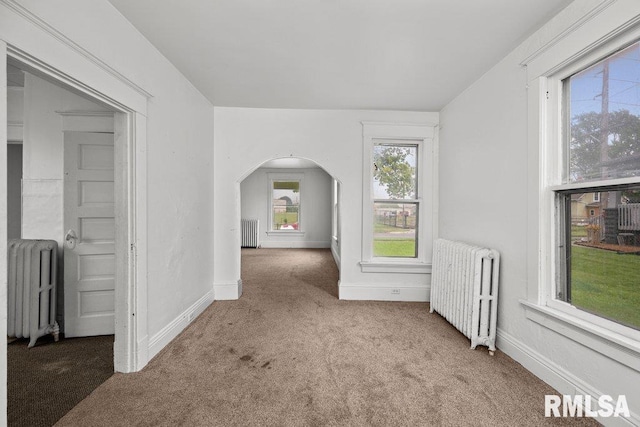 hallway featuring carpet flooring and radiator heating unit